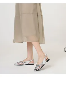 Elegant side view of silver woven slingback flat sandals worn by a model on plain background