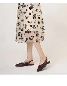 Detail view of brown pointed-toe slingback flats featuring an elegant cutout design