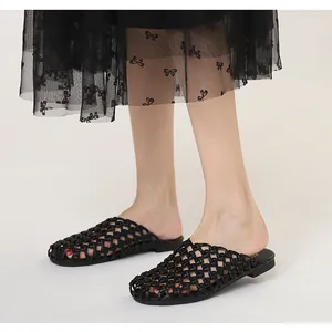 Vista de detalle de los mules trenzados negros vintage con un diseño plano calado
