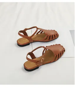 Detail view of brown French retro hollow-out closed-toe sandals with ankle straps.