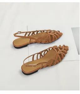 Close-up of brown woven slingback flat sandals with fine texture and buckle detail
