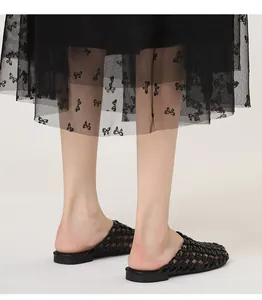 Vista detallada de mulas tejidas negras vintage con diseño calado para mujeres