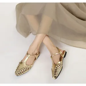 Elegant French style gold metallic woven T-strap flat sandals worn with a long skirt