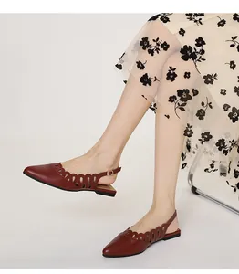 Detail of dark red pointed-toe flat slingbacks with elegant hollow-out wavy pattern