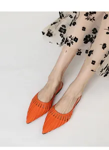 Gros plan de sandales plates orange pointues avec rayures ajourées