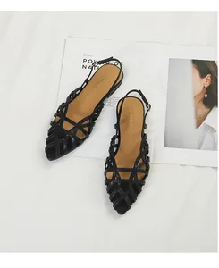 Lifestyle detail shot of black woven flat sandals for women with elegant buckle strap