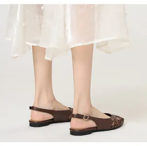 Detail view of brown woven pointed toe flat sandals with adjustable back strap