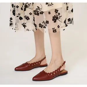 Detailed view of burgundy pointed-toe flats with elegant cutout design and slingback strap