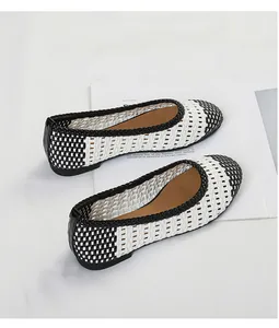 Primo piano di scarpe basse intrecciate bianche e nere in stile vintage elegante.