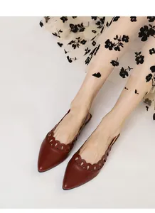 Detailed view of vintage pointed-toe slingback flats with decorative hollow cutout motifs