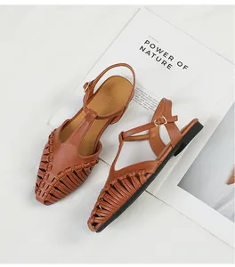 Detailed overhead view of brown woven T-strap flat sandals with a vintage design