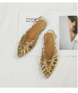 Detailed view of gold woven flat sandals with pointed toe and slingback strap