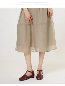 Close-up of burgundy woven leather T-strap sandals worn with a beige chiffon skirt