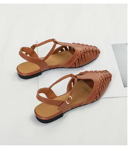 Detailed view of elegant brown woven T-strap pointed-toe flat sandals for summer