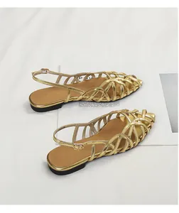 Detailed side view of gold woven Roman flat sandals featuring a stylish hollow peep-toe