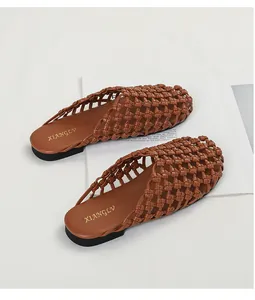 Primer plano de alta calidad de chinelas tejidas marrón vintage con suela plana para el verano