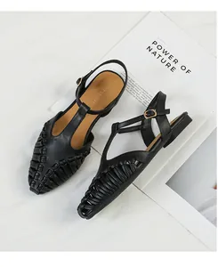Detailed look at French retro black woven T-strap flat sandals with pointed toe