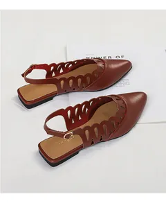 Close-up of vintage hollow-out brown slingback flat sandals with pointed toe design