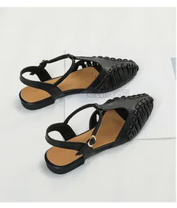 Detailed view of black French vintage pointed toe hollow woven flat sandals with T-strap