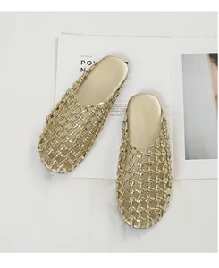 Detalle de mules dorados trenzados vintage con un elegante diseño de punta cerrada calada