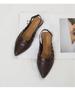 Close-up of vintage brown pointed-toe flats with scalloped hollow design and slingback strap