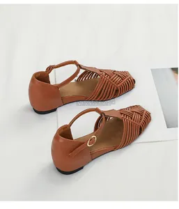 Detailed view of brown vintage woven sandals with elegant T-strap and square toe