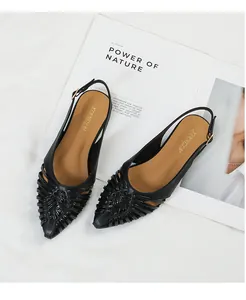 Detail view of retro black woven pointed-toe slingback flats with hollow-out design.
