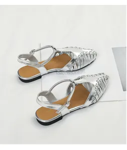 Detailed macro view of silver French vintage pointy-toe woven sandals with T-strap design