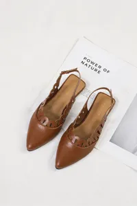 Detailed view of brown pointed-toe slingback flats with decorative hollow-out design