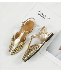 Close-up detail of golden metallic woven pointed-toe sandals with elegant T-strap