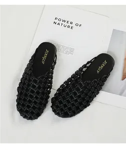 Primer plano de chinelas planas trenzadas negras con puntera cerrada