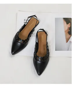 Elegant black pointed-toe slingback flats with scalloped hollow design on magazine