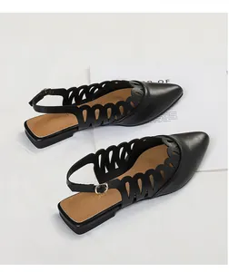 Detail of black pointed-toe slingback flats with elegant decorative cutout patterns