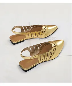 Detailed view of vintage gold pointed-toe slingback flats with elegant cutout design