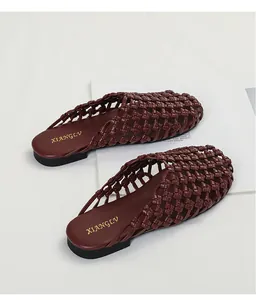 Primer plano de mules burdeos trenzados a mano con un elegante diseño calado y vintage