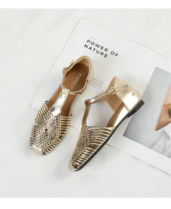 Detailed macro view of retro gold woven sandals featuring a stylish T-strap and square toe design