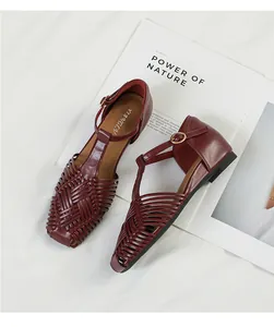 Detailed view of burgundy retro woven T-strap sandals featuring square toe design and low wedge