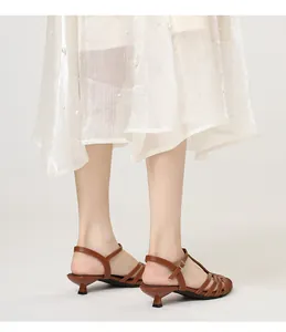 Detail of brown strappy kitten heel sandals with woven design and adjustable ankle strap