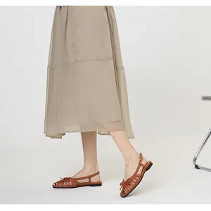 Side view of elegant brown woven hollow-out closed-toe Roman sandals with cute bow-knot detail