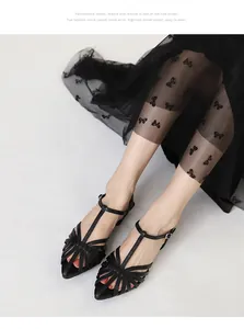 Detailed view of black pointed-toe woven sandal shoes with elegant T-strap design