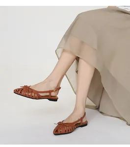 French style brown woven hollow-out sandals with bow detail worn with beige skirt