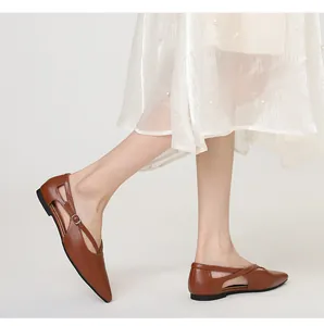 Elegante braune spitze flache Schuhe mit Kreuzriemen und Schnalle, Seitenansicht am Modell