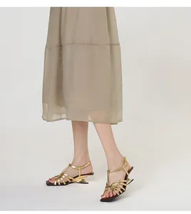 Close-up of elegant gold strappy sandals with a unique geometric heel design