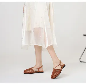 Macro view of brown hand-woven closed-toe Roman sandals with adjustable ankle strap
