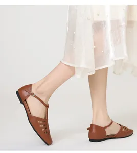 Detailed side view of vintage brown square toe hollow-out T-strap flats for women