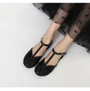Vista dettagliata delle scarpe basse in mesh nero retrò con cinturino a T intrecciato