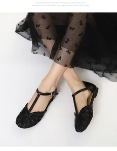 Primo piano di ballerine in rete nera vintage con design a cinturino a T intrecciato