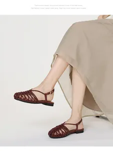 Detailed view of women's hand-woven closed-toe Roman sandals with ankle strap on model