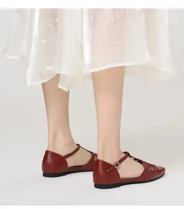 Elegant detail showing the side profile of vintage red T-strap hollow-out flat sandals