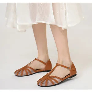 Dettaglio ravvicinato di ballerine vintage marroni in mesh con cinturino a T e fibbia